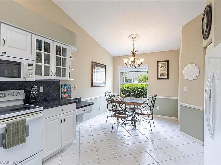 Dining room with light tile patterned flooring and a chandelier