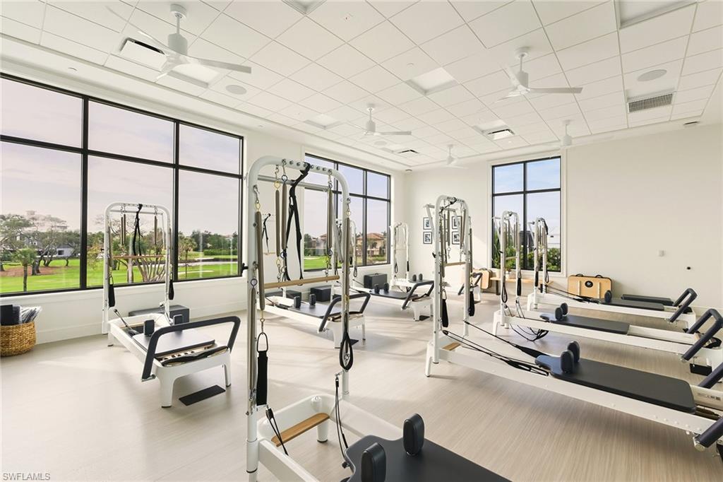 Exercise room featuring a ceiling fan and a paneled ceiling