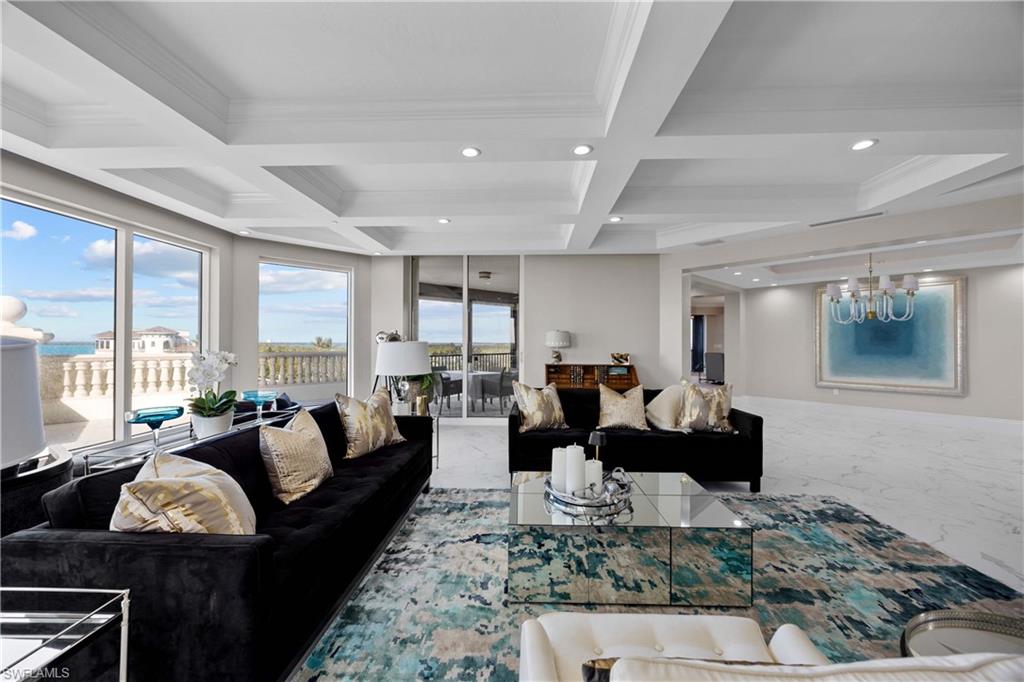 Living room featuring beam ceiling, ornamental molding, and coffered ceiling