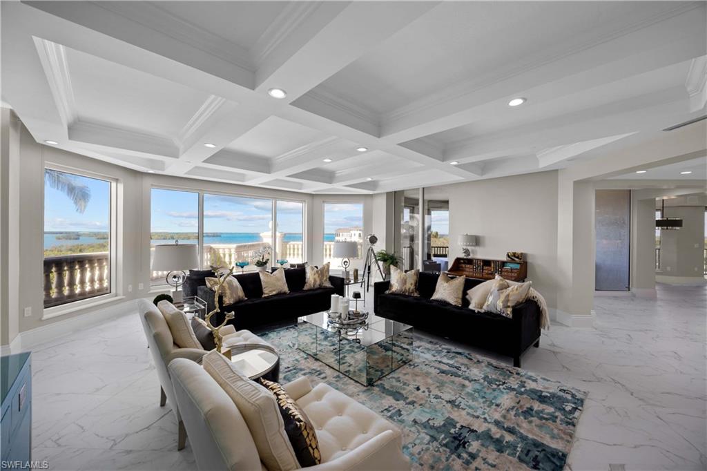 Living room with beamed ceiling, a healthy amount of sunlight, ornamental molding, and coffered ceiling