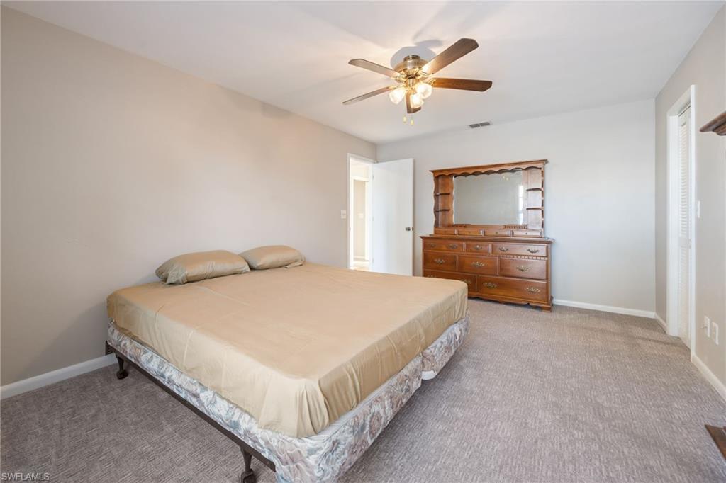 Bedroom with light colored carpet and a ceiling fan