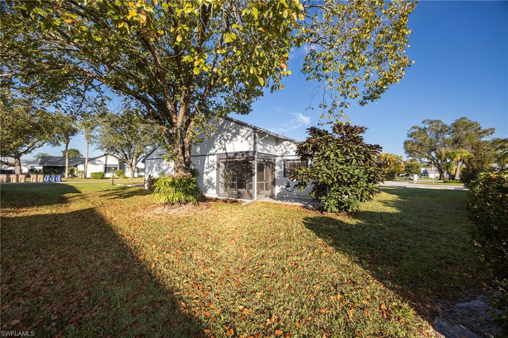 View of green lawn featuring a sunroom
