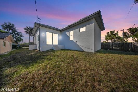 Back of house at dusk featuring stucco siding