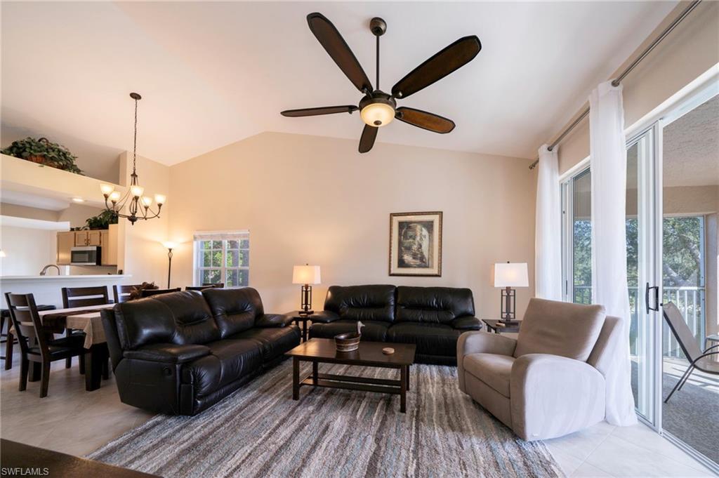Living area with dining room and a vaulted ceiling.