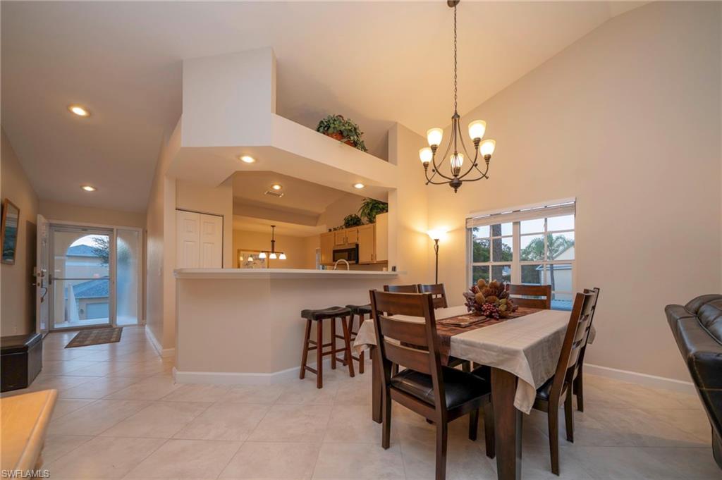 Dining room with a chandelier, healthy amount of natural light, high vaulted ceiling