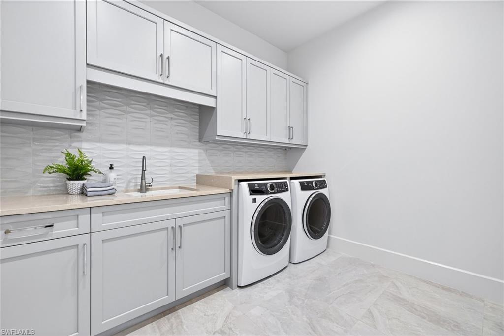 Large laundry room, with full size washer and dryer ,sink with plenty of cabinets for storage