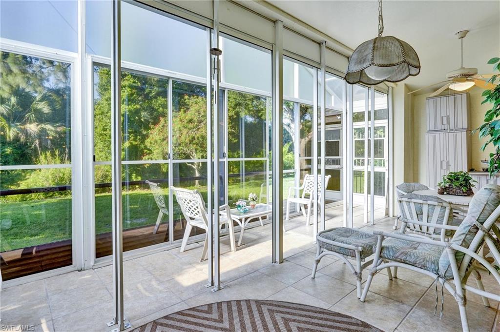 Screened-in porch featuring tiled flooring, a ceiling fan, and built-in white cabinetry