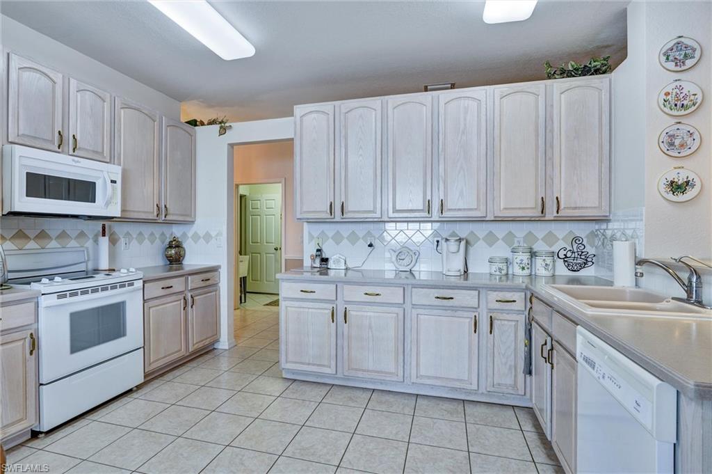 Kitchen featuring extensive light-finish cabinetry, tile flooring, and laminate countertops