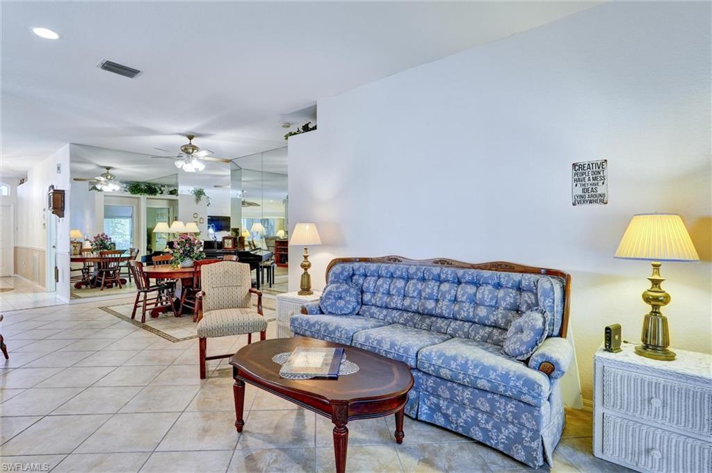 Spacious interior featuring tile flooring, mirrored accent walls, and a recessed ceiling vent