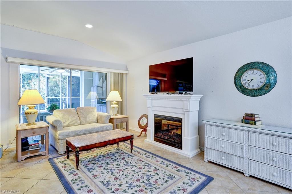 Living area featuring a white mantel, an integrated fireplace, and tile flooring