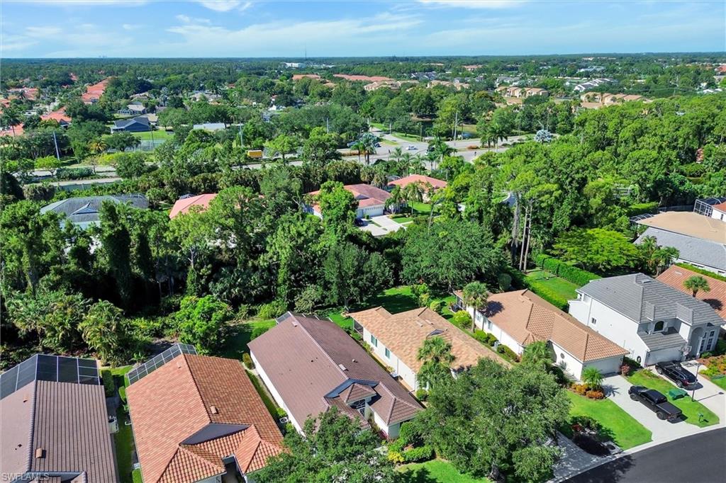 Aerial perspective showcasing a residential neighborhood with diverse architectural styles, mature landscaping, and tree-lined streets