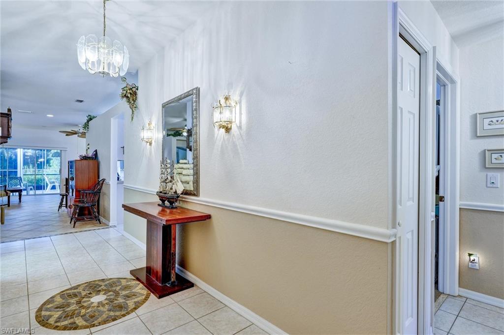 Entryway featuring tile flooring, wainscoting, and decorative wall sconces