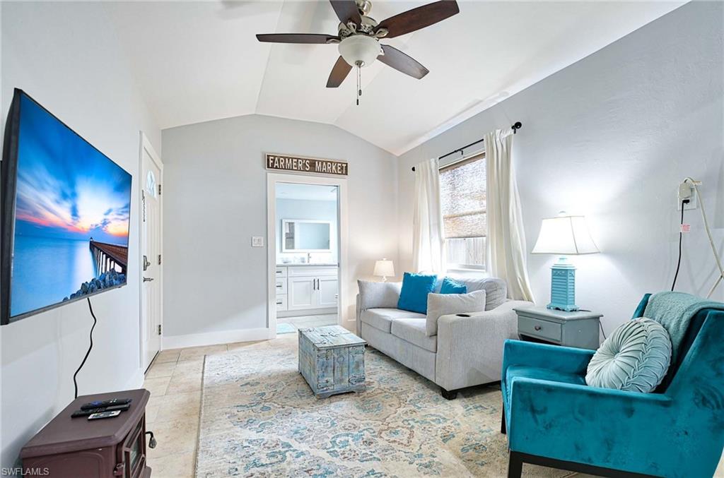 Living area with a ceiling fan and lofted ceiling