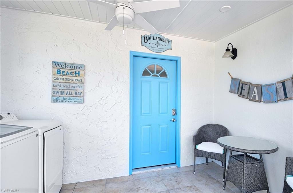 Property entrance featuring stucco siding and independent washer and dryer