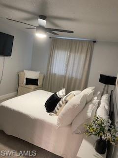 Carpeted bedroom with a textured ceiling and ceiling fan