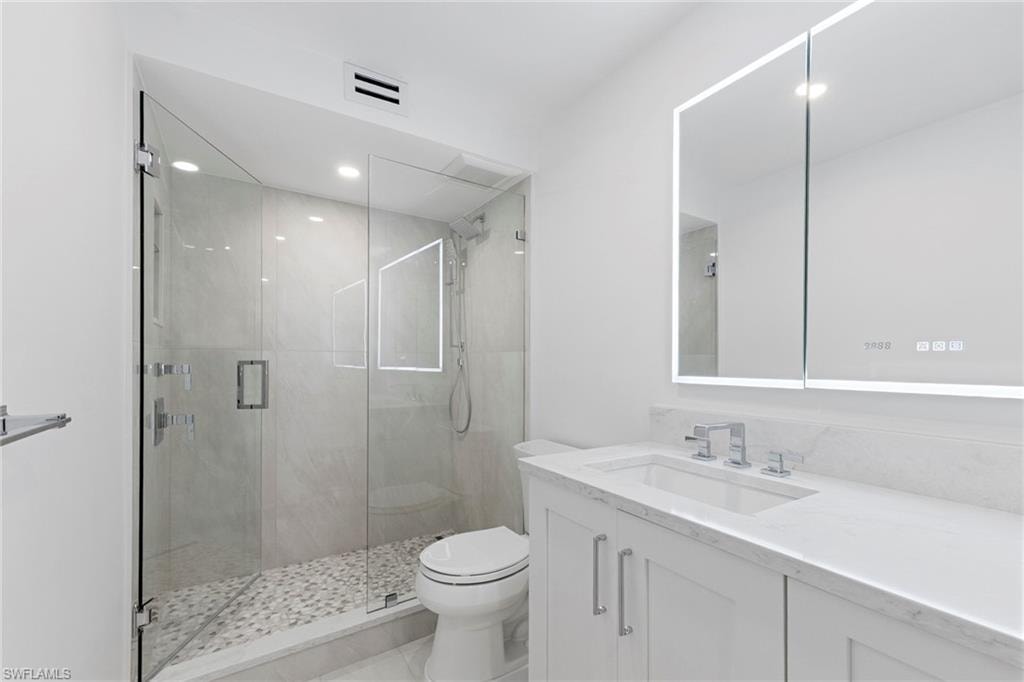 Bathroom featuring vanity, a shower stall, and recessed lighting