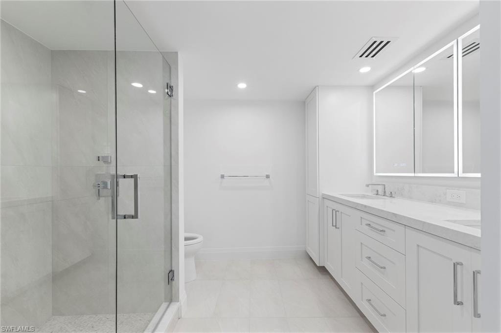 Full bath with double vanity, a shower stall, recessed lighting, and light tile patterned flooring