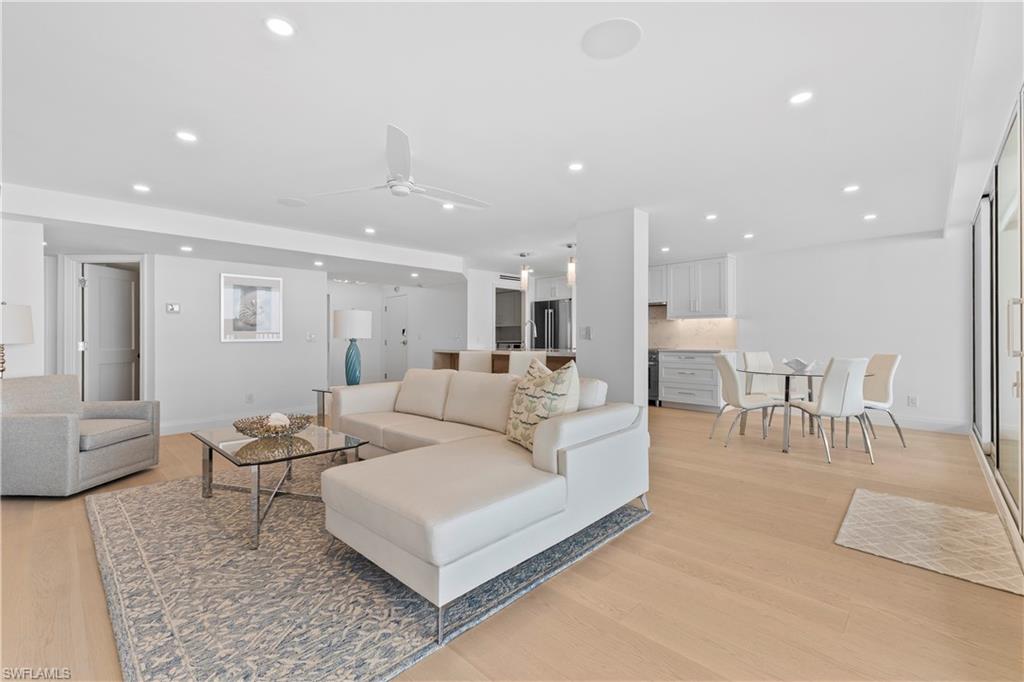 Living room featuring light wood-style flooring, ceiling fan, and recessed lighting