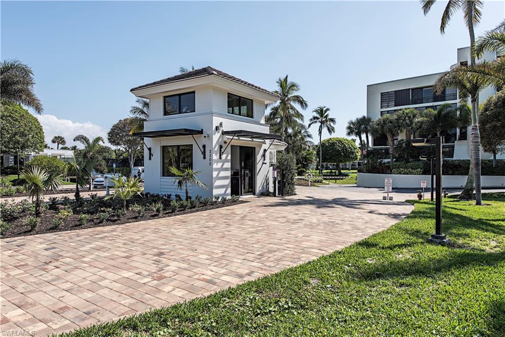 View of front of property featuring a front yard, decorative driveway, and stucco siding
