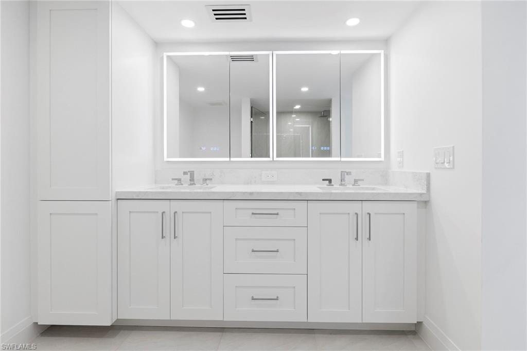 Bathroom featuring double vanity, a stall shower, and recessed lighting