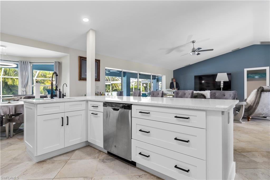 Kitchen area overlooking lisland counter and living room with open views to the pool.