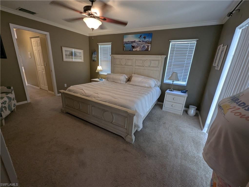 Bedroom with ornamental molding, carpet, and ceiling fan