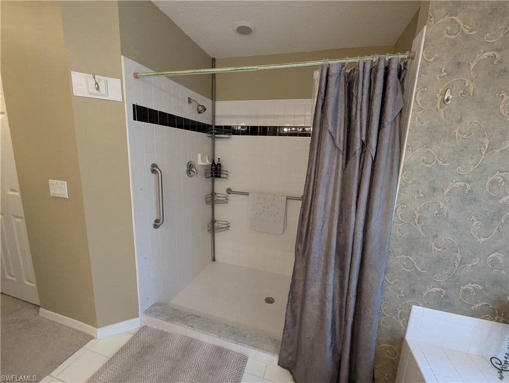 Bathroom with tile patterned flooring and a shower stall