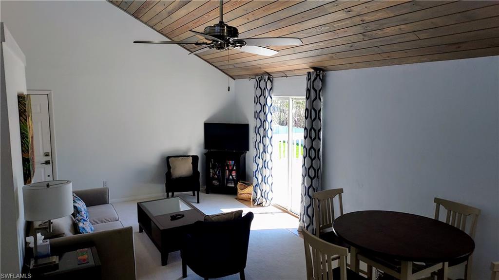 Carpeted living area with wood ceiling, lofted ceiling, and ceiling fan