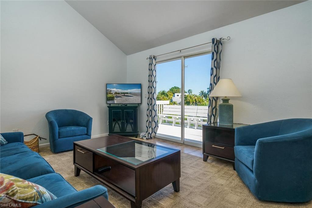 Living room featuring vaulted ceiling and carpet