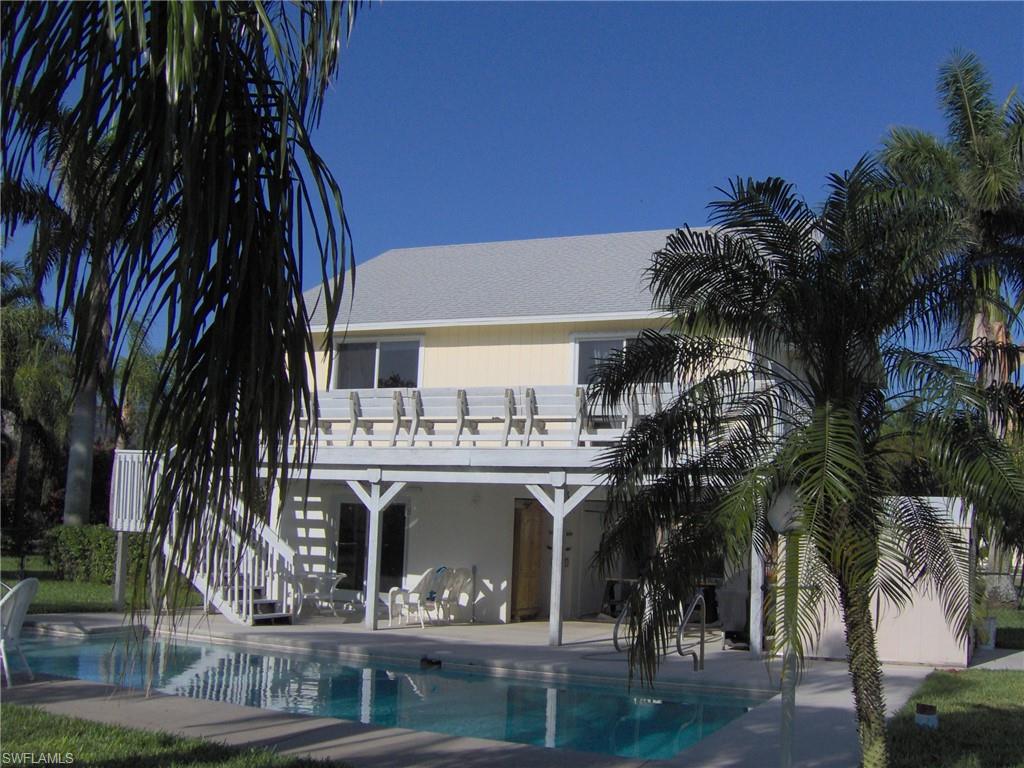 Back of house featuring a patio area, an outdoor pool, and stairs