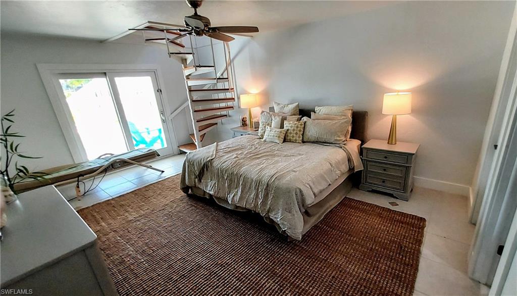 Bedroom with tile patterned flooring, access to exterior, and ceiling fan