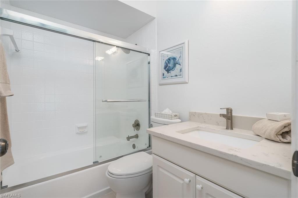 Bathroom featuring bath / shower combo with glass door and vanity