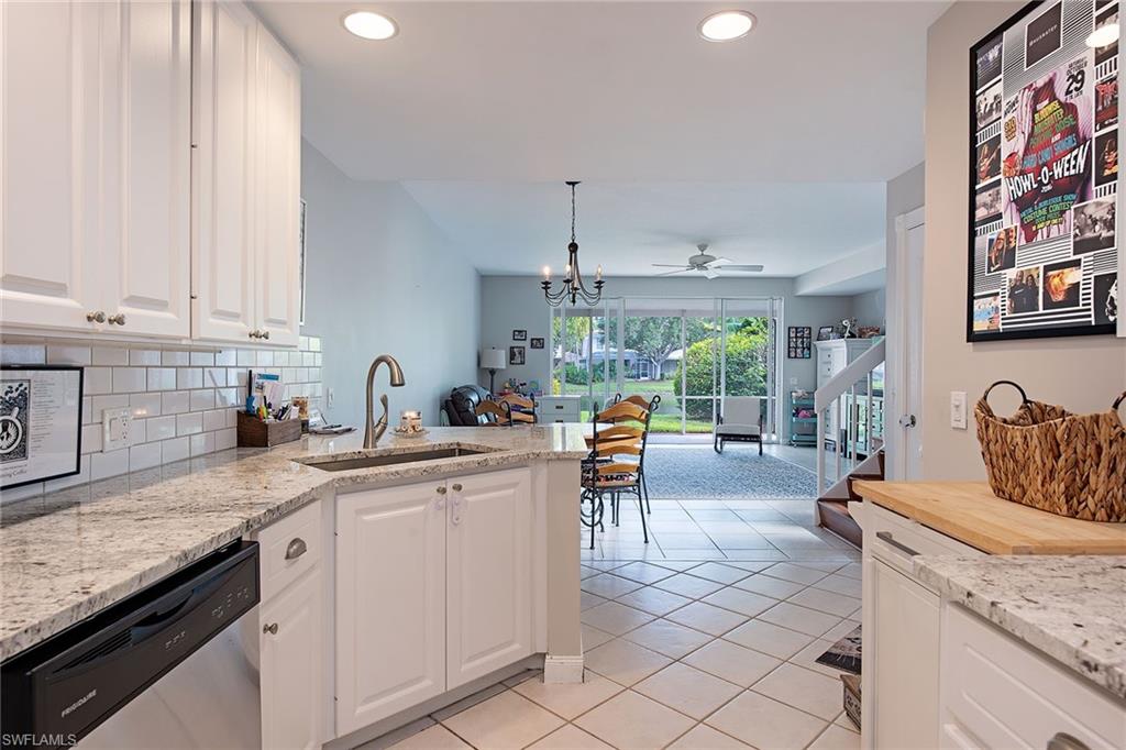 Kitchen with white cabinetry, light stone countertops, tile backsplash, stainless steel appliances, and recessed lighting