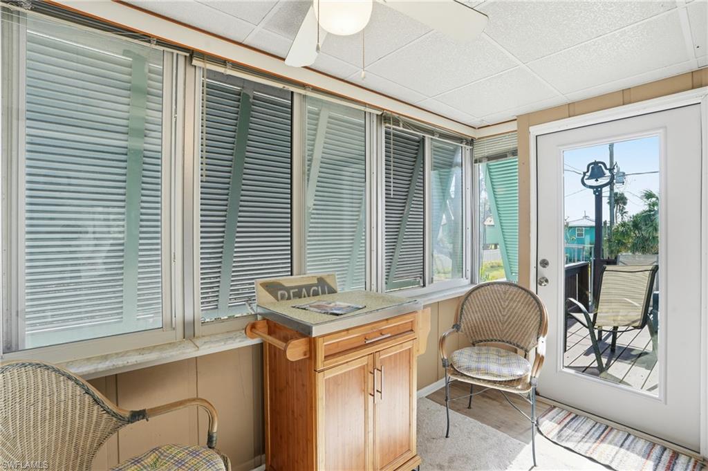Sunroom featuring a paneled ceiling and wood finished floors - Virtually Edited Image
