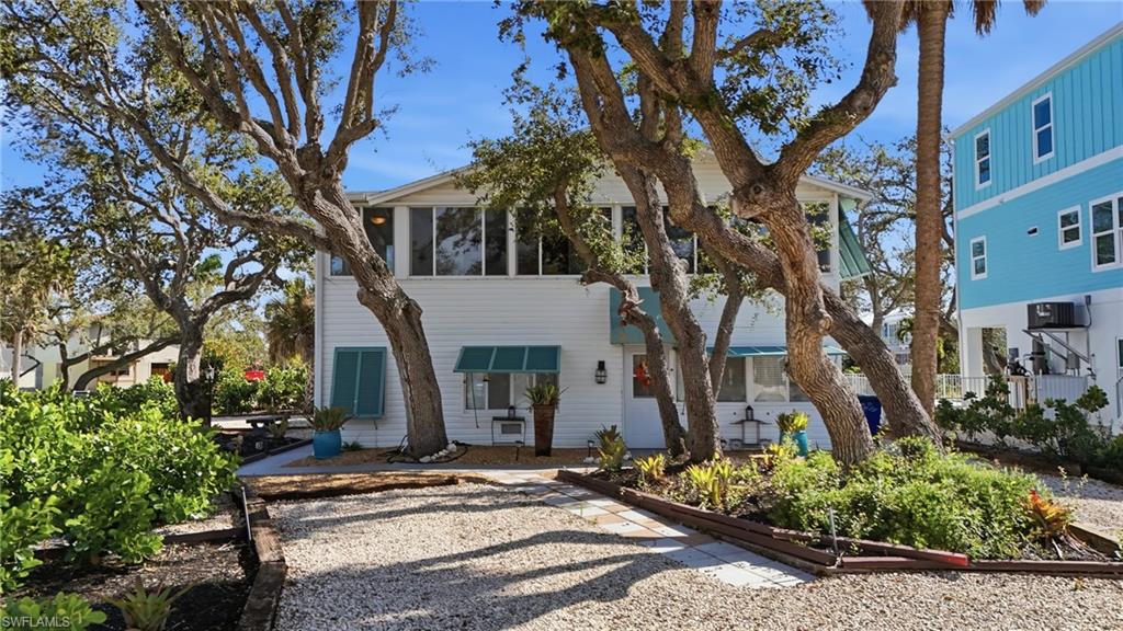 View of front of home with a sunroom - Virtually Edited Image