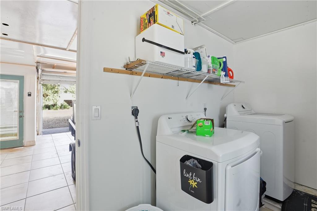 Laundry room featuring independent washer and dryer and light tile patterned flooring - Virtually Edited Image