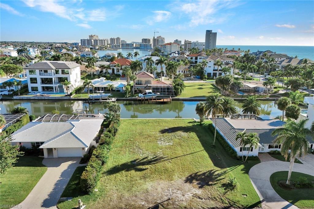 Aerial perspective of suburban area featuring a large body of water and city skyline