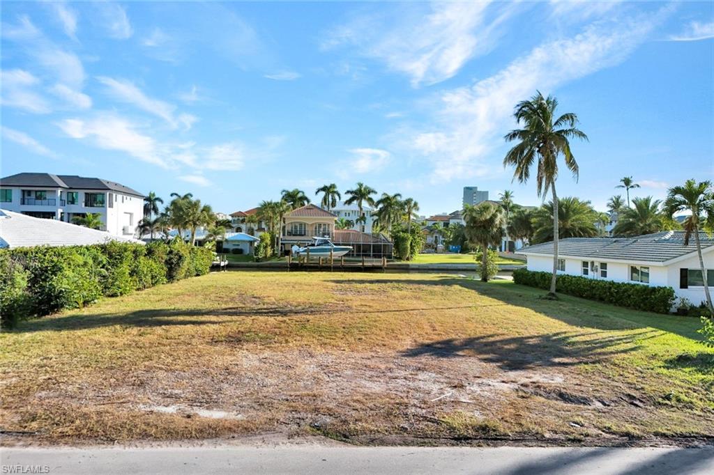 View of green lawn with a residential view