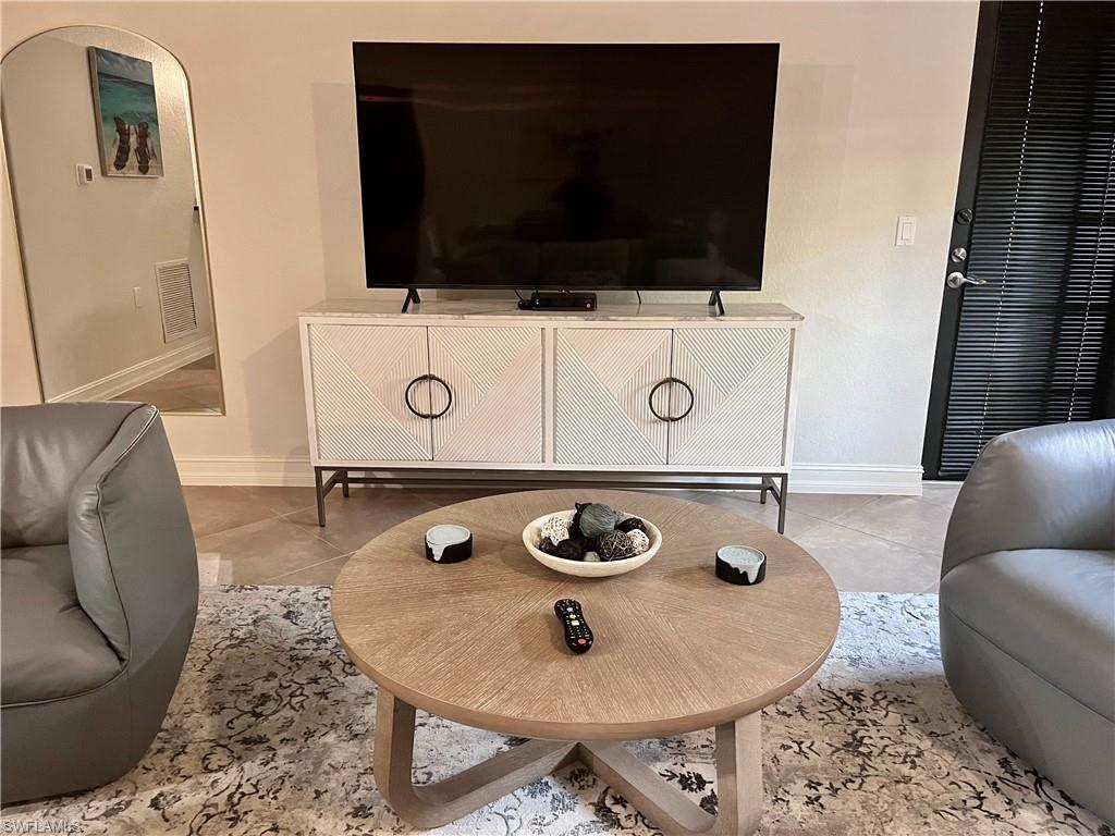 Living room featuring light tile floors and 65" TV