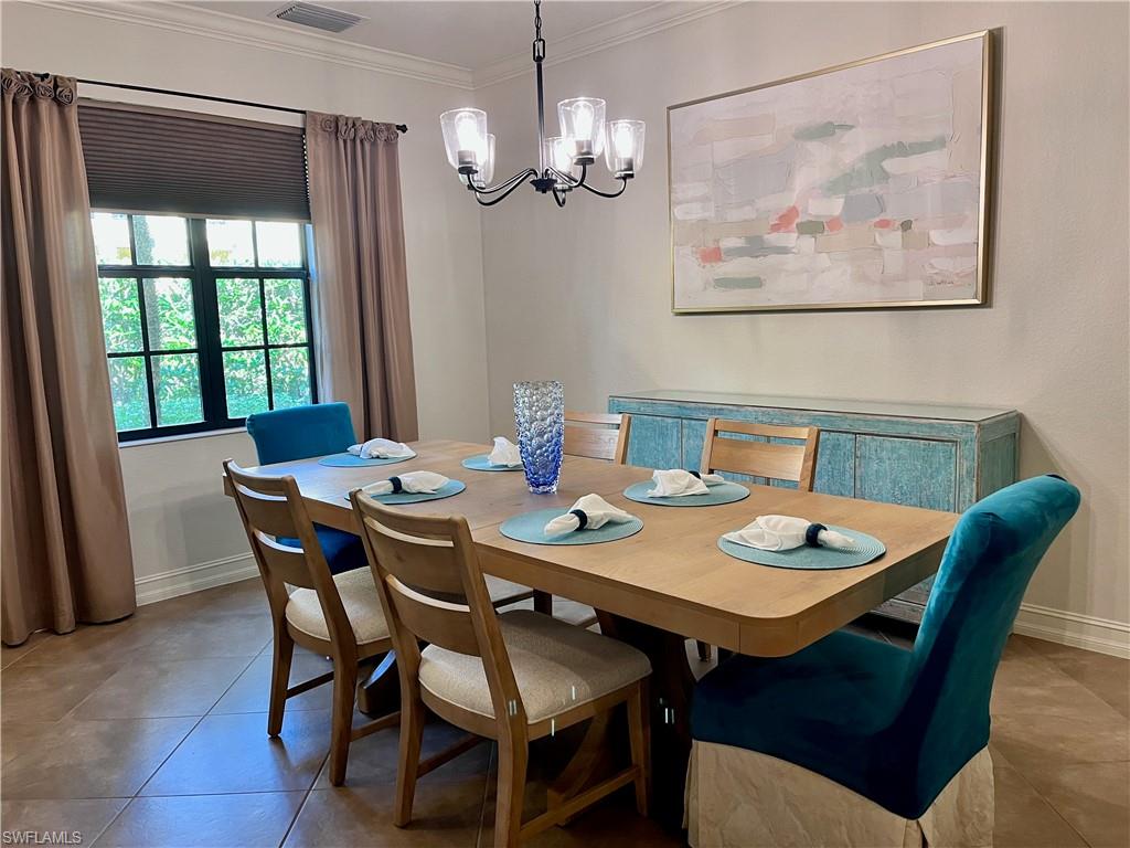 Dining space for 6 with a chandelier and server