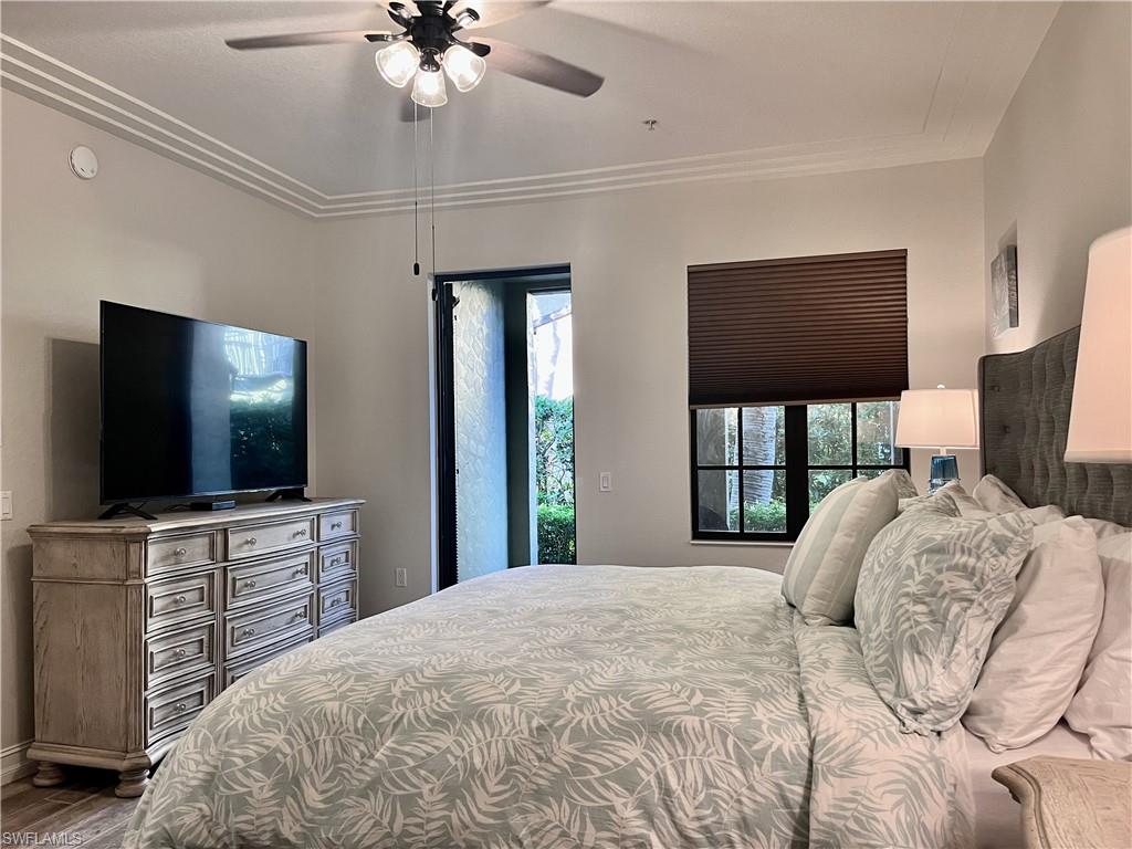 Bedroom with hardwood / wood-style flooring, ceiling fan, and ornamental molding
