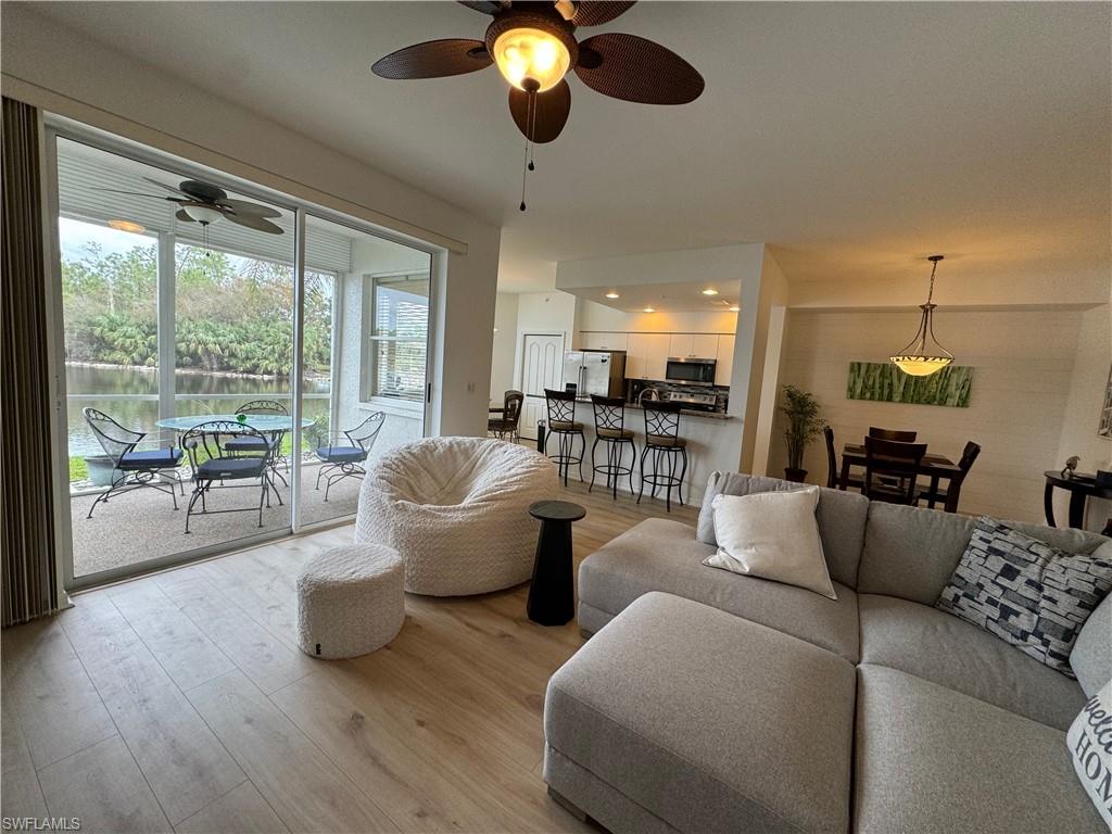 Living room with ceiling fan and light wood-type flooring