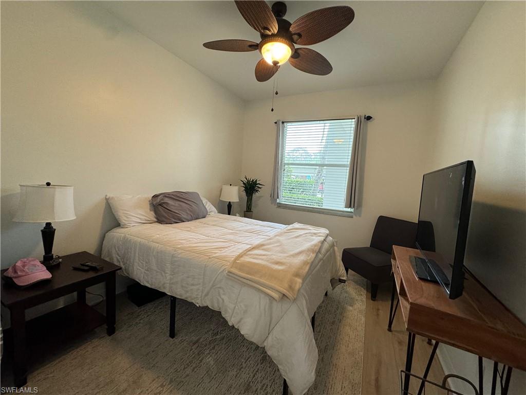 Bedroom featuring light hardwood / wood-style floors, ceiling fan, and vaulted ceiling