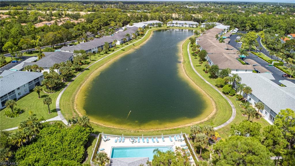 Aerial perspective of suburban area with a large body of water and a pool