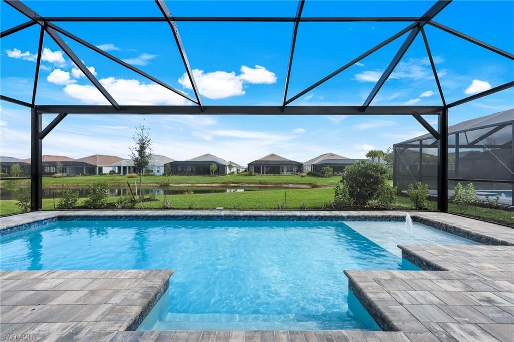Swimming pool with a sunroom, glass enclosure, a residential view, and a patio