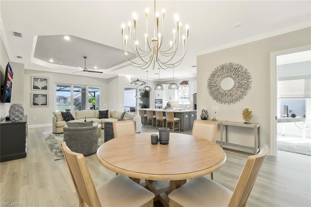 Dining space featuring a chandelier, crown molding, light wood-type flooring, a ceiling fan, and recessed lighting