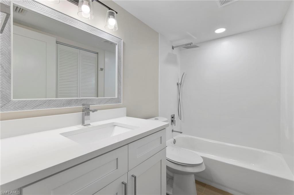 Bathroom featuring vanity, shower / tub combination, a closet, and recessed lighting