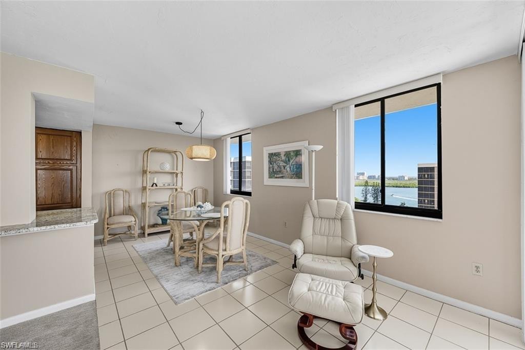 Dining area featuring light tile patterned flooring and a water view