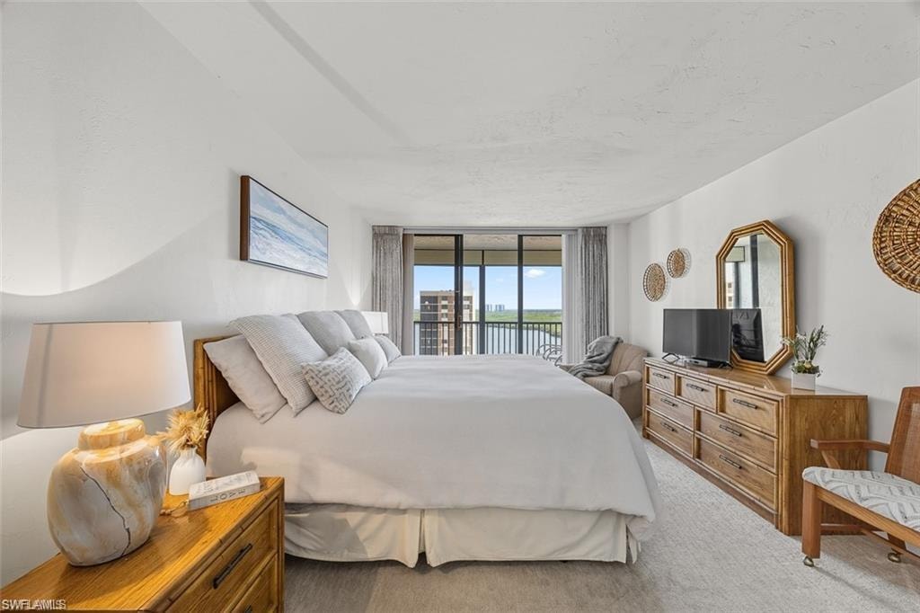 Bedroom with access to outside, a wall of windows, and carpet