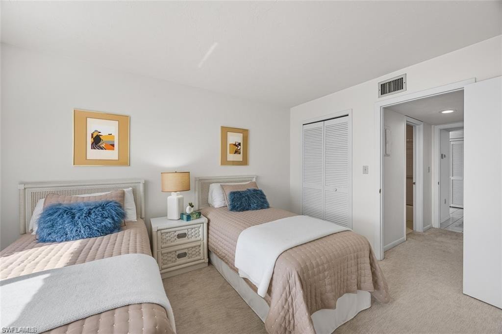Carpeted bedroom with a closet and baseboards